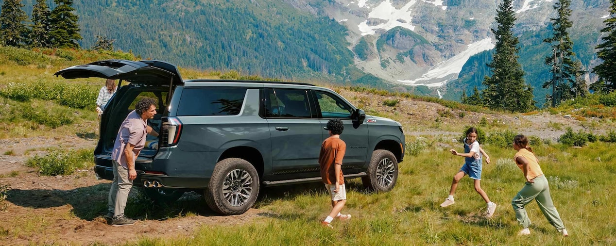 Chevrolet Suburban Z71 2025 en paisaje montañoso con familia disfrutando de la naturaleza, destacando amplitud, aventura y versatilidad