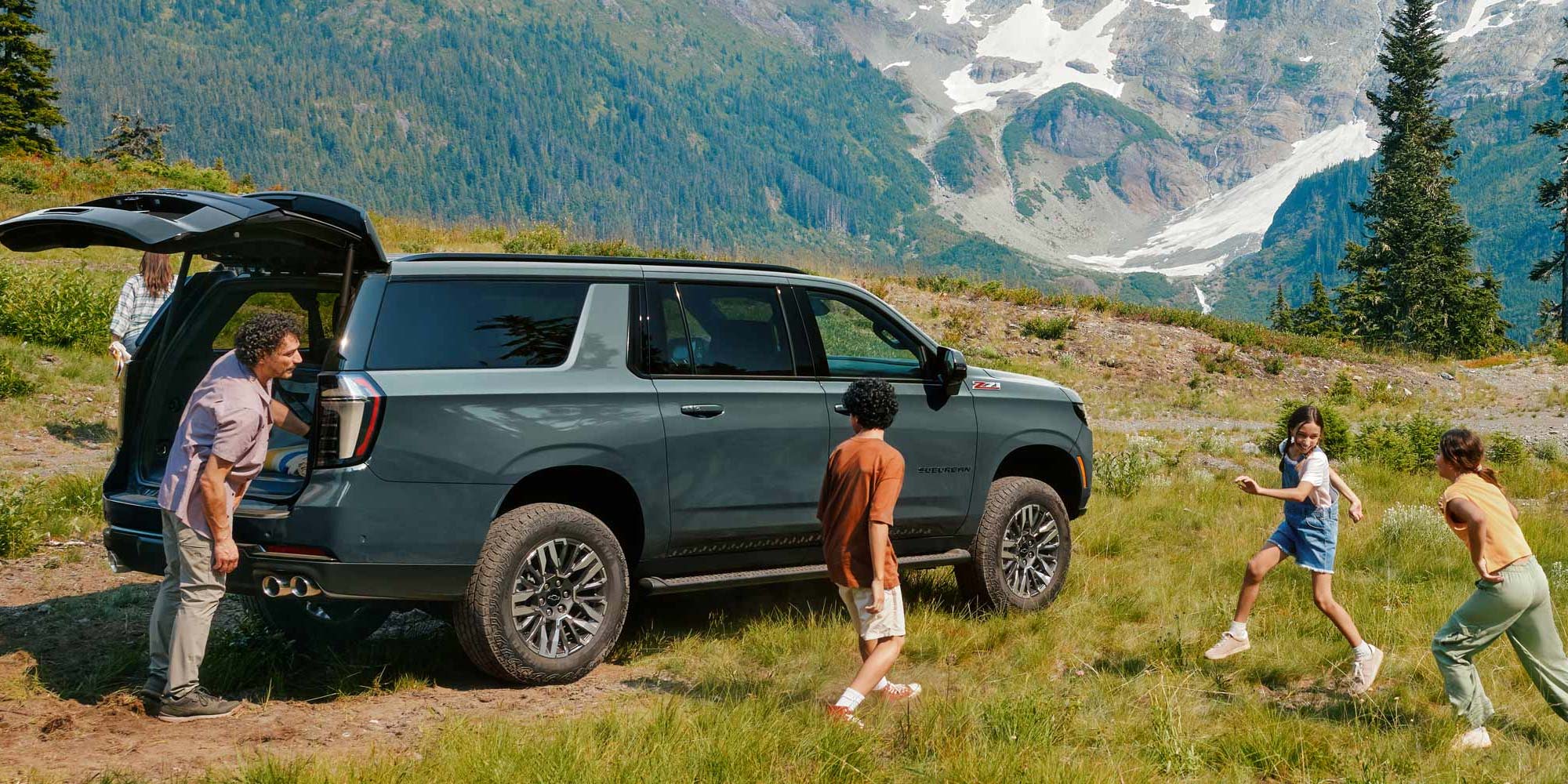 Familia disfrutando al aire libre junto a su Chevrolet Suburban Z71 en zona montañosa